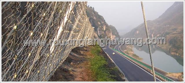公路一侧的边坡脚下安装着以勾花网隔栅和钢丝绳网为主的栅栏式被动防护网