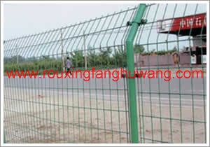 在加油站对面的公路的另一侧安装的浸塑护栏网