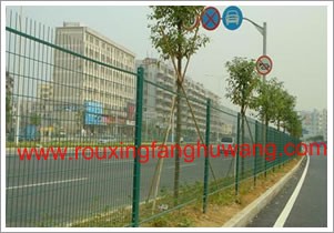 公路边种植着绿树的绿化带边上的公路护栏网
